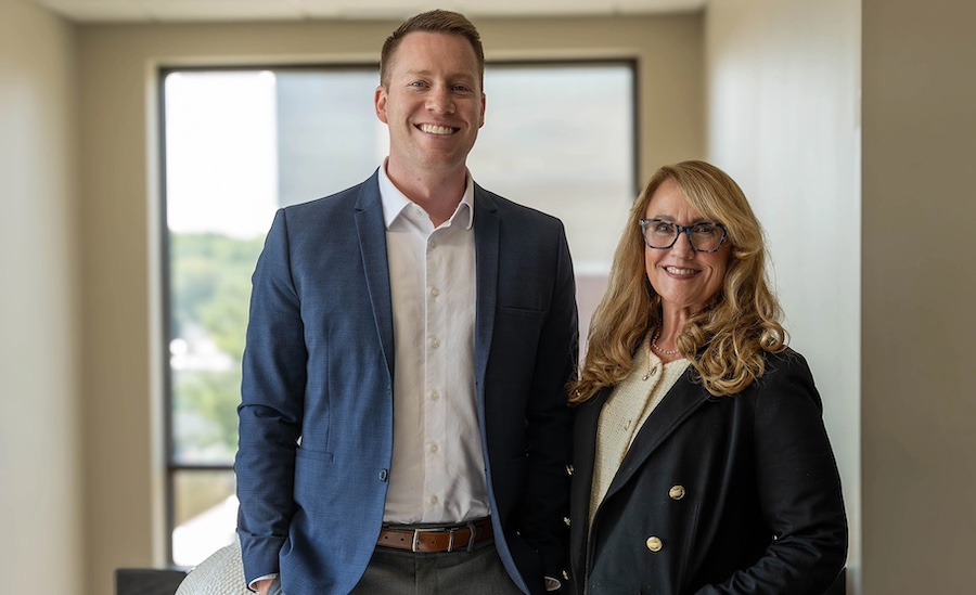 Jeremy Keel and Stacey Janssen stand professionally in the Janssen office
