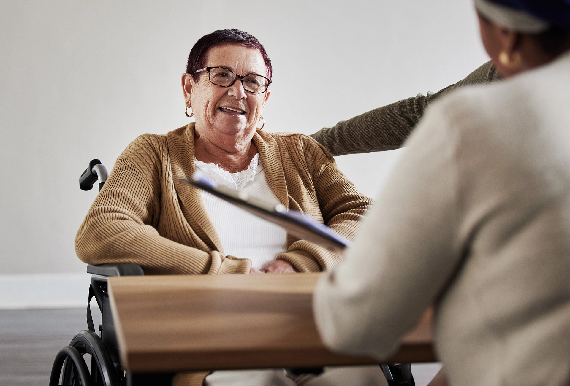 Elderly woman in a wheelchair meeting with an elder law attorney to discuss long-term care and guardianship planning