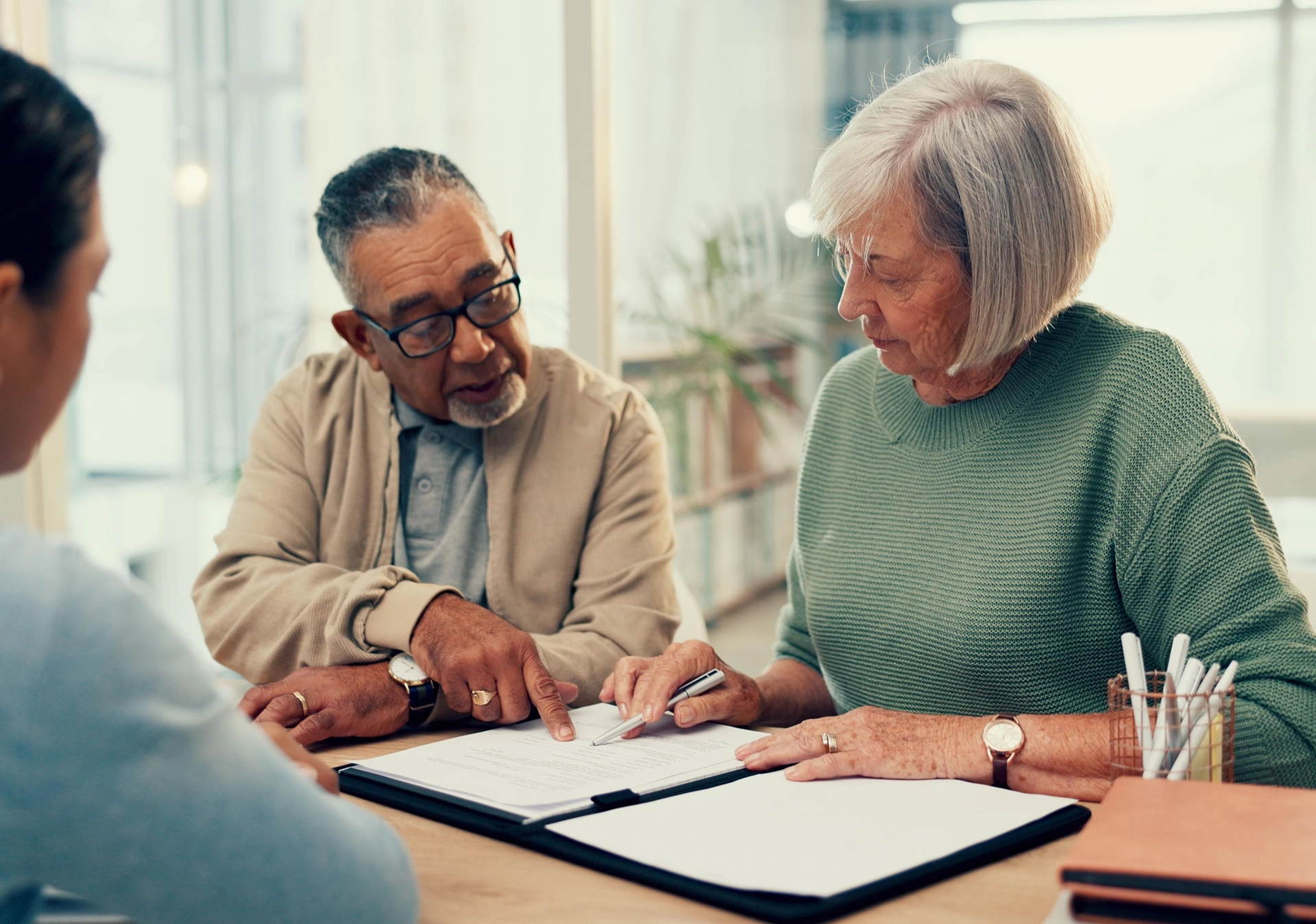 Elderly couple reviewing long-term care planning documents with an advisor to prepare for future care needs
