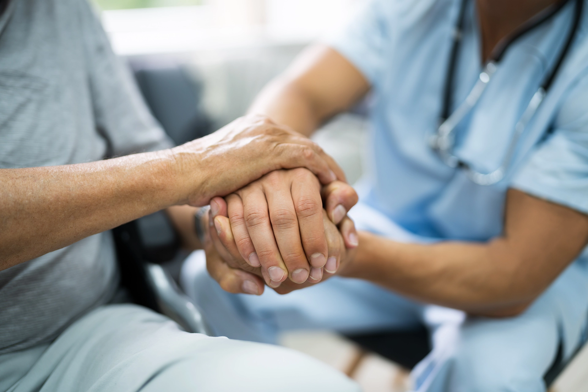 Close-up of a Medicaid planning attorney holding an elderly person’s hands, offering support and guidance