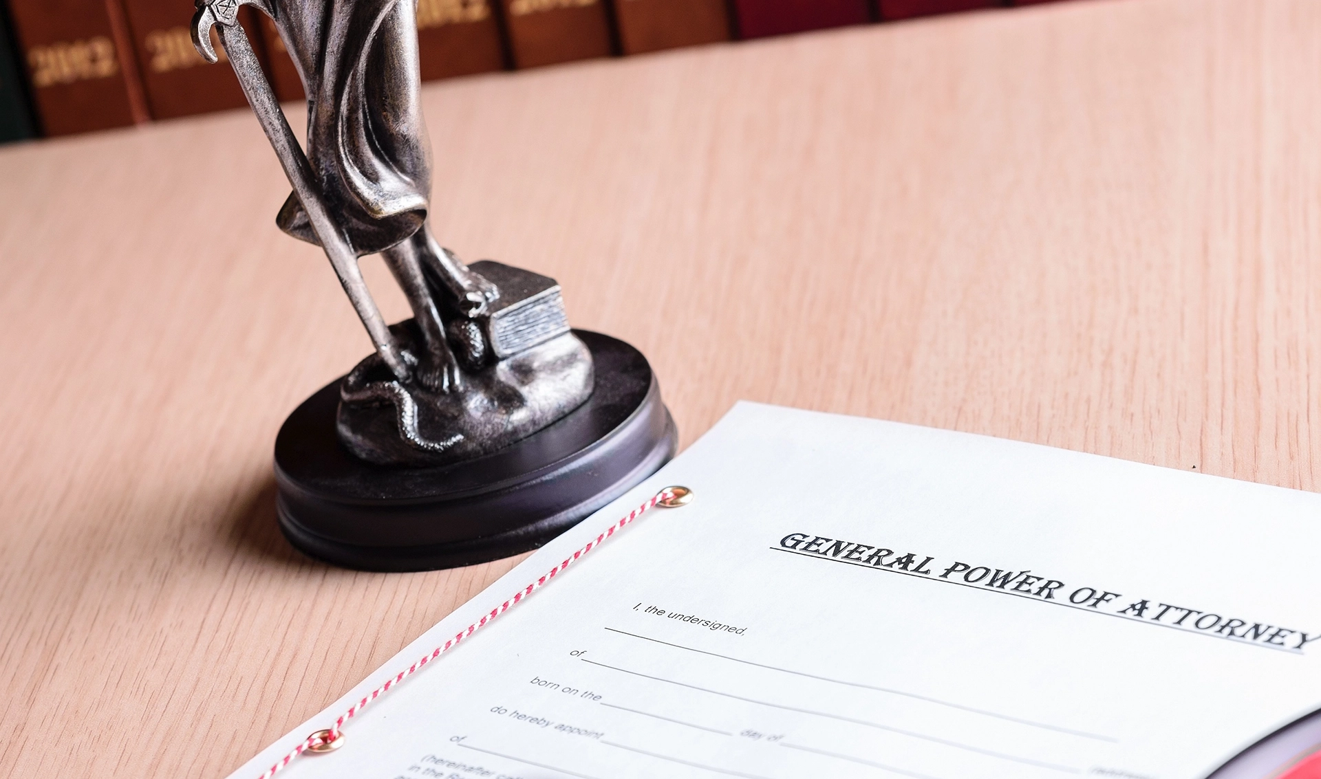 General Power of Attorney document on a desk beside a Lady Justice statue and notary seal
